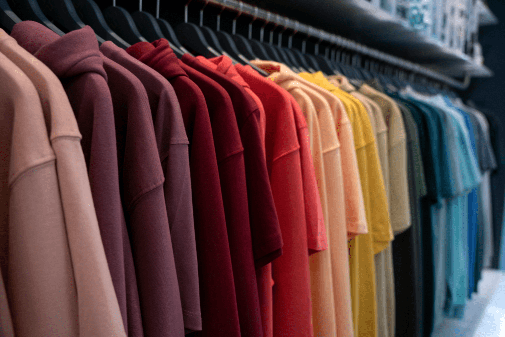 Colored tees and hoodies hanging on a rack